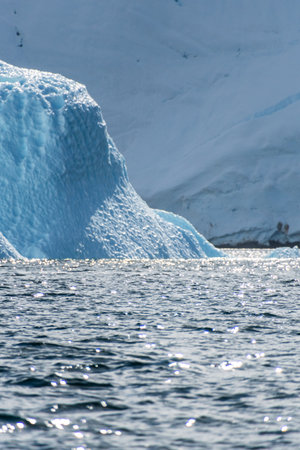 A tranquil Antarctic landscape, near Graham passage along Charlotte Bay, highlighting stark reflections, rugged mountains, and impressive icebergs.の写真素材