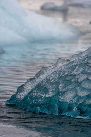 Detail of a patch of Antarctic sea ice, containing wonderous shapes and deep blue colours.