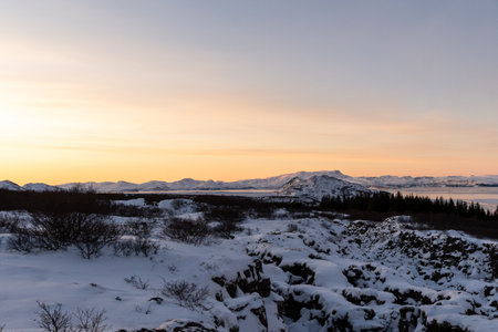 A scenic outdoor landscape shot from the Thingvellir National Park in Iceland on a beautiful sunny winter afternoon. This snowcovered landscape marks the continental divide between America and Europe.の写真素材