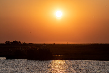 Telephoto shot of the setting sun over the chobe river on a bright winter afternoon in Botswana.の写真素材