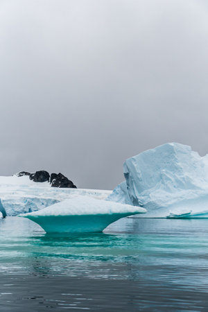 An Antarctic landscape shot near Cuverville island, highlighting mountains and icebergs.の写真素材