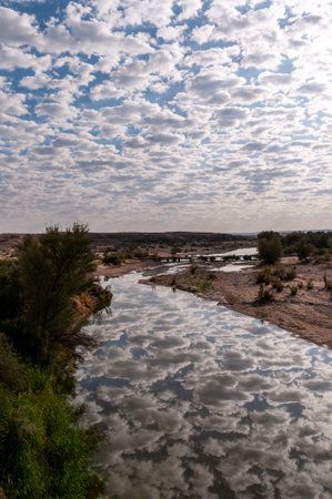 Low hanging clouds are reflected in a water of the Fish river in southern Namibia.の写真素材