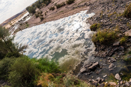 Low scattered clouds are reflected in the river in Southern Namibiaの写真素材