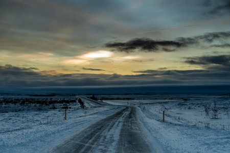 An early morning scene of a snow covered landscape in southern iceland. The sky is filled with stratospheric clouds which refract bright colours.の写真素材