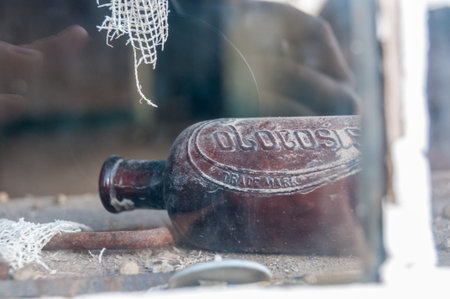 Scene from the abandoned ghost town of Bodie, California. Here, an empty bottle in an abandoned window is shown.の写真素材
