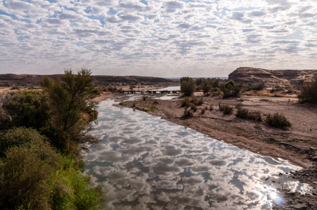 Low hanging clouds are reflected in a water of the Fish river in southern Namibia.の写真素材