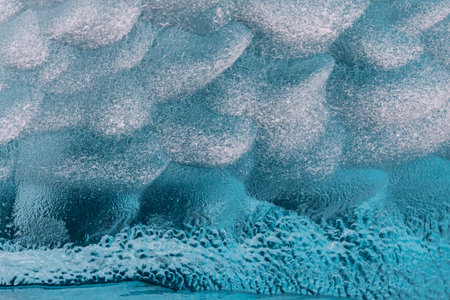 Detail of a patch of Antarctic sea ice, containing wonderous shapes and deep blue colours.