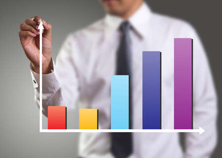 Male hand drawing a chart isolated on gray backgroundの写真素材