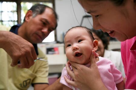 6 month old Asian baby girl having a haircut の写真素材