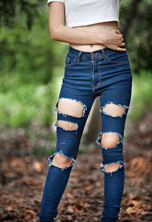 Woman with ripped jeansの写真素材