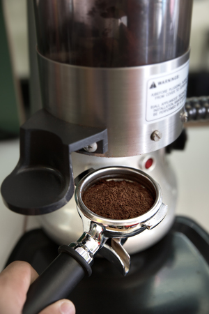 prepares espresso in his coffee shop; close-upの写真素材