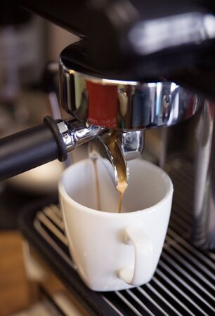 prepares espresso in his coffee shop; close-upの写真素材
