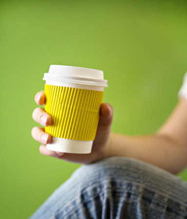 Young woman drinking coffee from disposable cupの写真素材