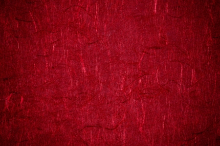 Grunge textured recycled red paper with natural fiber parts with vignettingの写真素材