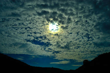 the photographer's view of the summer sky with the sun and broken clouds evoking the emotions of romanceの写真素材