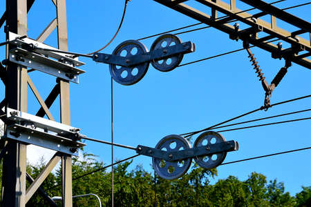 view of the system of tensioning pulleys of the supply trolley on the railway double-track line, including their anchoring on the supporting columnsの写真素材