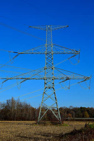 picture Mast of a high voltage power line in autumn landscape with blue cloudless sky background, North Moravia, Czech Republicの写真素材