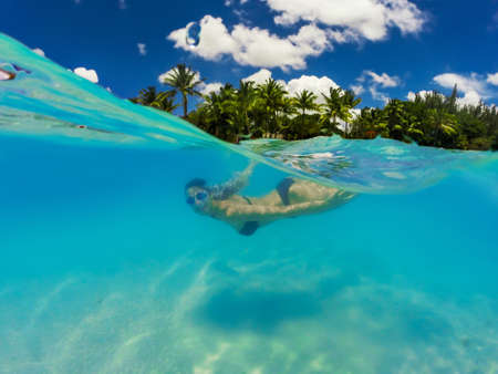 Young pretty woman swimming under water enjoying summer holidays at beautiful tropical island. Holidays conceptの写真素材