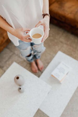 The girl in the pants is drinking coffeeの写真素材