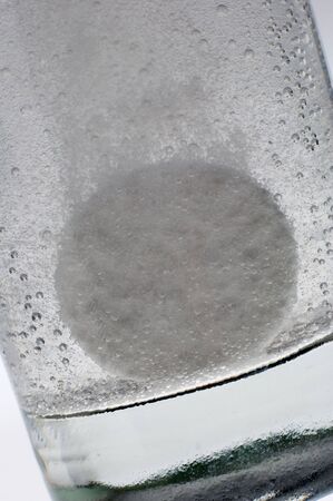 tablet dissolving in a glass of Waterの写真素材