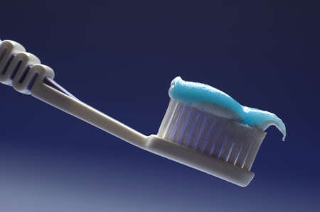 tooth brush in blue cup close upの写真素材