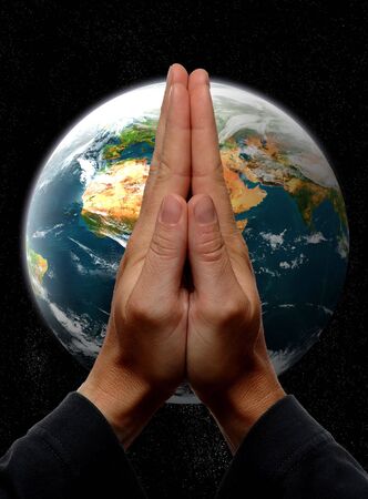 praying hands in front of earth conceptの写真素材