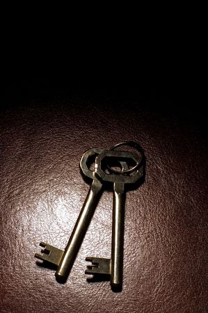 two keys on brown leather spot lightの写真素材