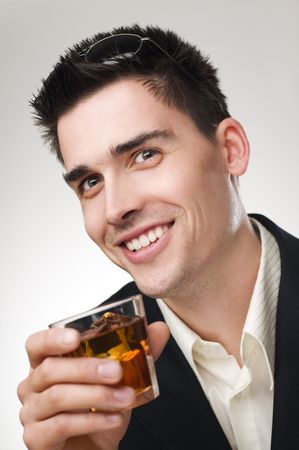 Young handsome business man drinking whiskey close upの写真素材