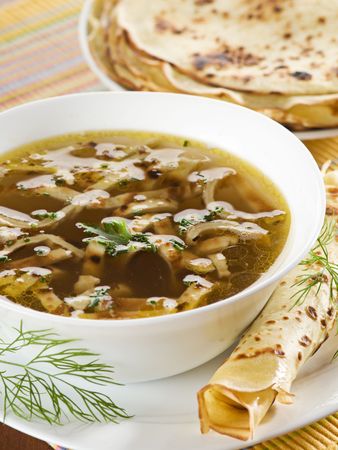 Beef or chicken soup with sliced pancake close upの写真素材