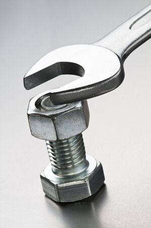 Spanner and silver bolt on metallic background close upの写真素材
