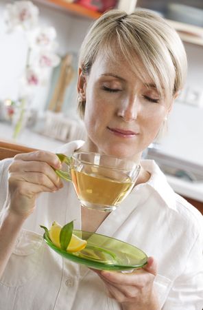 Young woman drinking green tea close upの写真素材