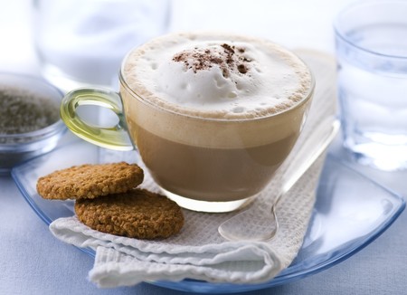 Fresh cappuccino in glass with cookie close up の写真素材