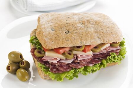Fresh salami, cheese, olives and tomato sandwich close up の写真素材
