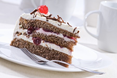 Chocolate cake with cream and cherry close up shootの写真素材