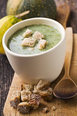 Fresh green pumpkin soup with bread close upの写真素材