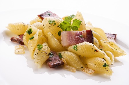 Baked conchiglioni pasta with spices and bacon close upの写真素材