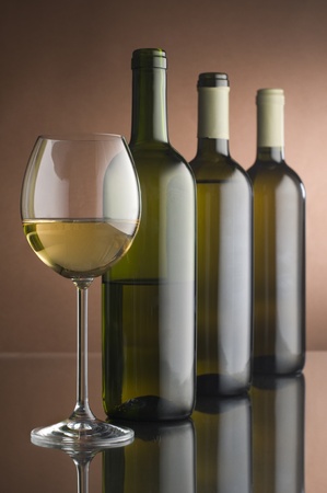Bottles with white wine and glass close upの写真素材