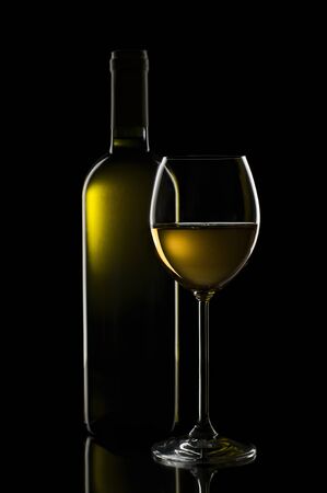 White wine in glass on black background close upの写真素材