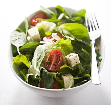 Fresh mixed green salad with mozzarella and tomatoesの写真素材