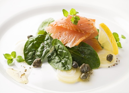 Smoked salmon with spinach, capers, and spring onions close upの写真素材