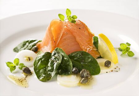 Smoked salmon with spinach, capers, and spring onions close upの写真素材