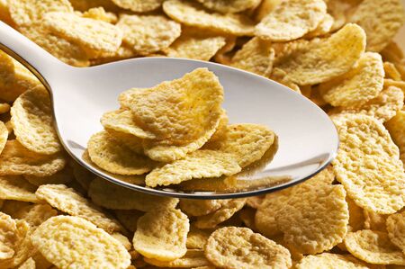 Fresh golden corn flakes on a spoon close up