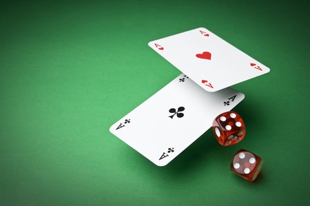 Cards and dices on green background close up