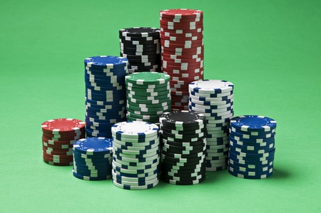 Gambling chips on green background close up