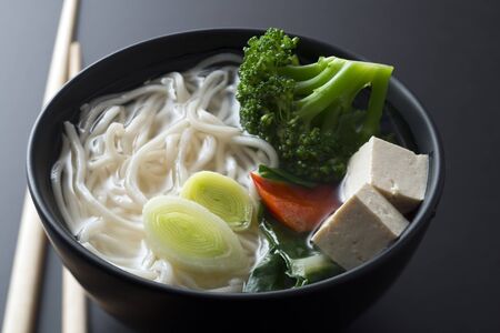 Chinese soup with noodles tofu and vegetables close upの写真素材