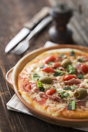 Fresh pizza with ham, cheese and tomato close upの写真素材