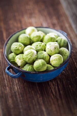 Raw brussels sprouts in blue bowl close upの写真素材