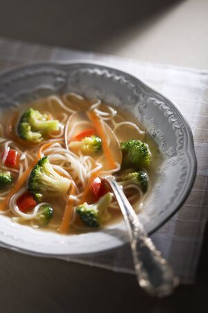 Chicken stock with noodles and vegetables close upの写真素材