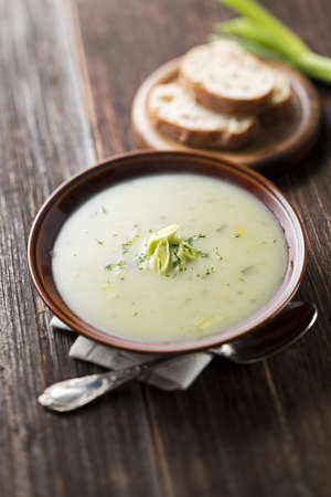 Fresh leek soup on wooden background close upの写真素材