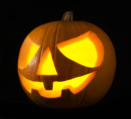 Scary old jack-o-lantern on black background close upの写真素材